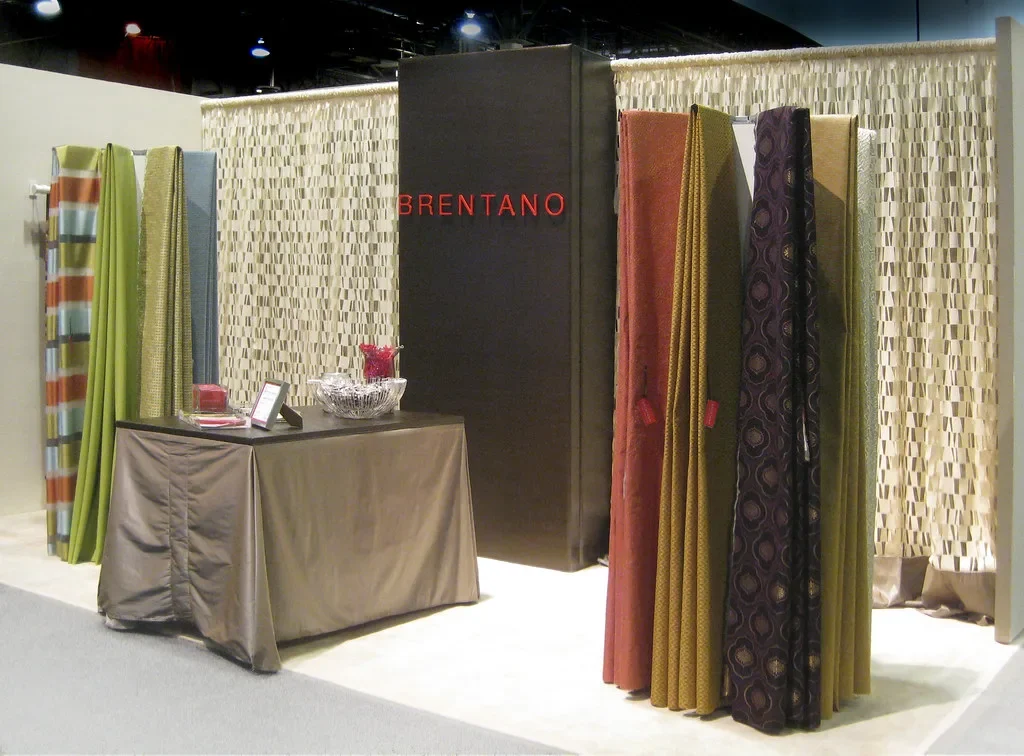 Inline booth at a trade show with a back wall and display table