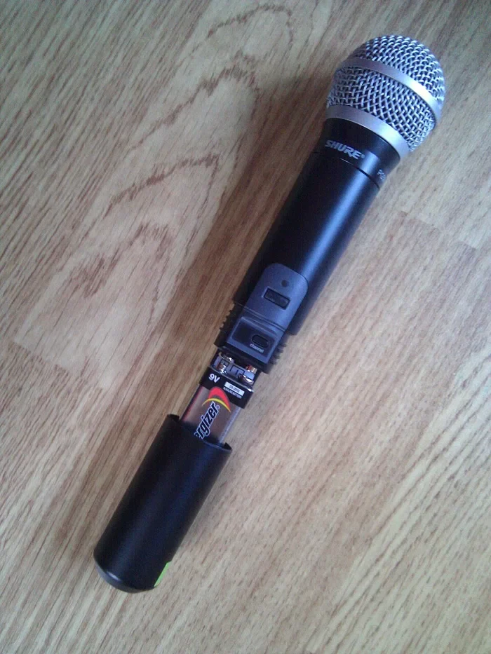 Handheld wireless microphone with the transmitter battery compartment open